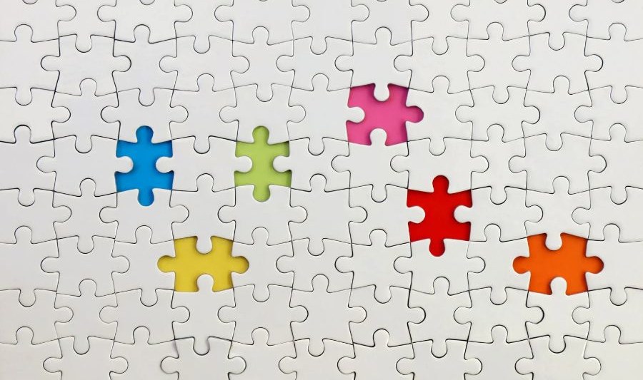 Jigsaw Puzzle on Red Weißes Puzzle: In der Mitte sind sechs bunte Puzzle-Teile integriert.