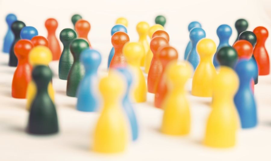 Vielfältige moderne Welt Bunte Spielfiguren stehen durcheinander vor einem hellen Hintergrund.