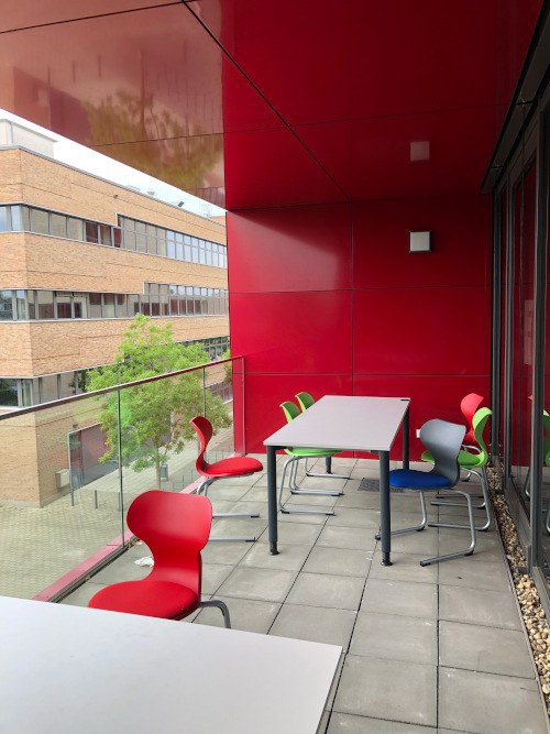 Lernbalkon HS Ruhr West Lernbalkon mit einer Glasbalustrade, Tischen und Stühlen an der Hochschule Ruhr West