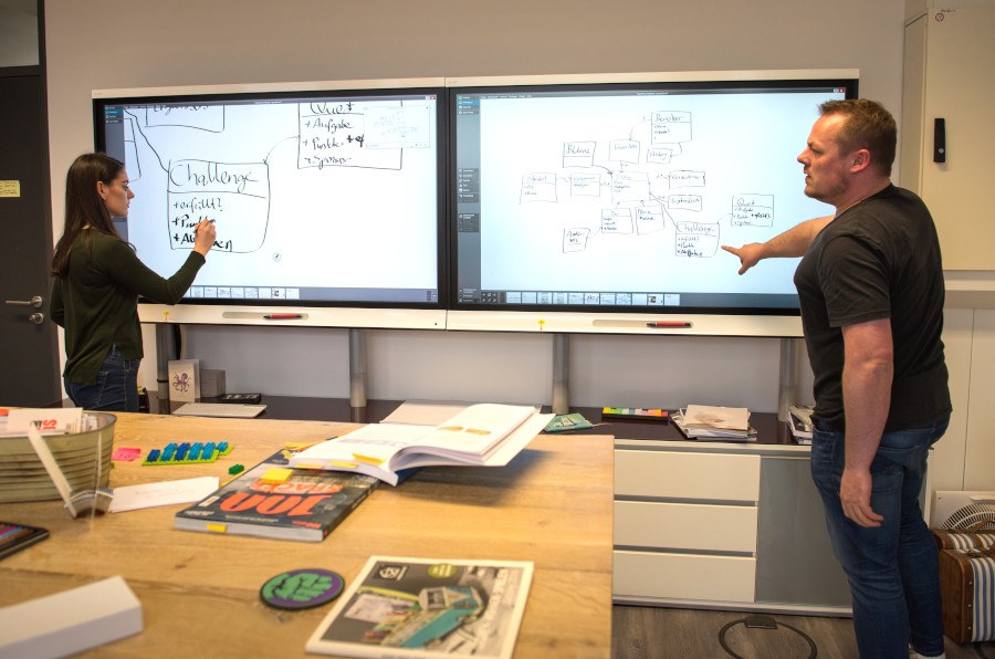 Studierende am interaktiven Whiteboard Zwei Studierende arbeiten gemeinsam an einem interaktiven Whiteboard