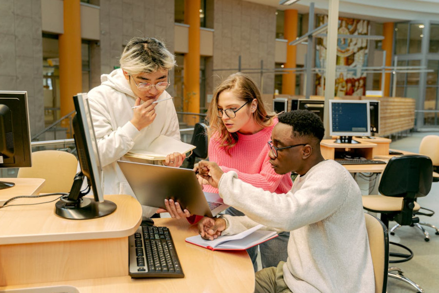 Studierende mit Laptop in der Bibliothek